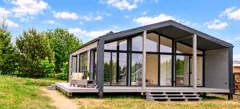 Barnhouse 76.2 — Giebel mit Panoramaverglasung und Terrasse, Sommer